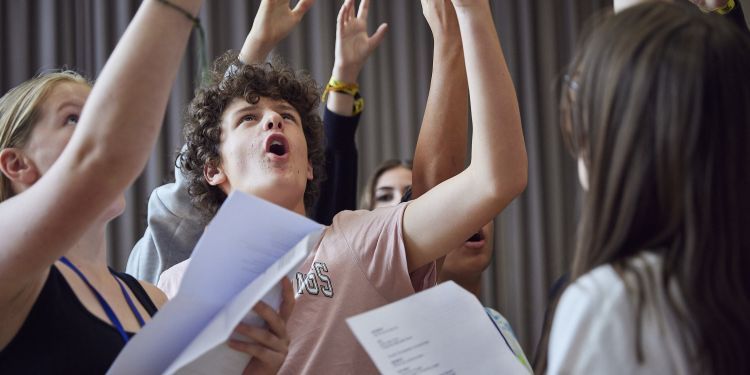 A group of young people performing in a scene.