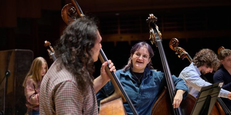 Strings students on stage smiling and talking