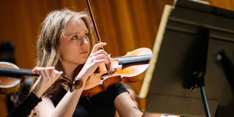 Female presenting violin player on stage 