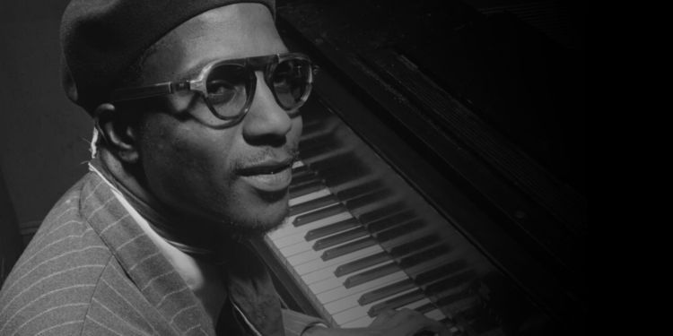 Black and white headshot of Monk sat at a piano
