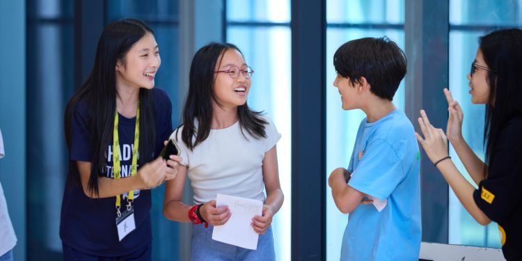 A group of young children huddle together laughing