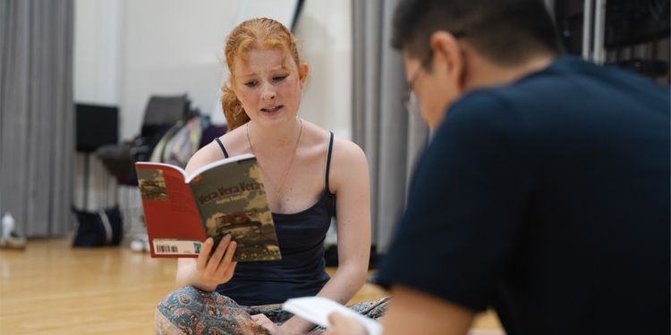 Two young drama students reading from their scripts