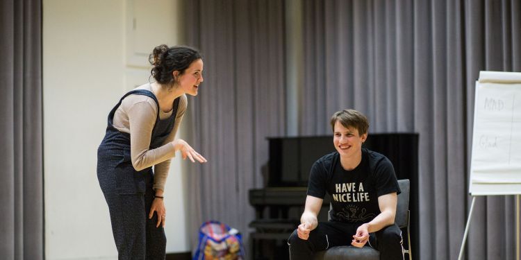 Male (sitting) and female (standing) students participating in an improvisation class