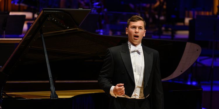 Vocal student on stage wearing a formal suit