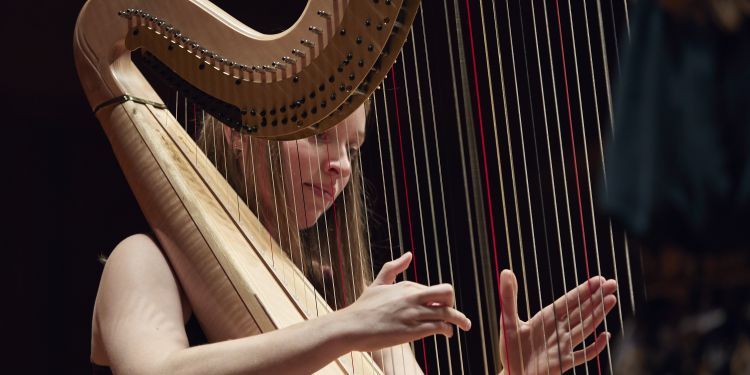 A Guildhall harpist student on stage performing