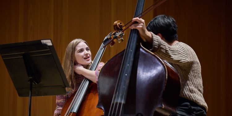 Strings students on stage talking at one another