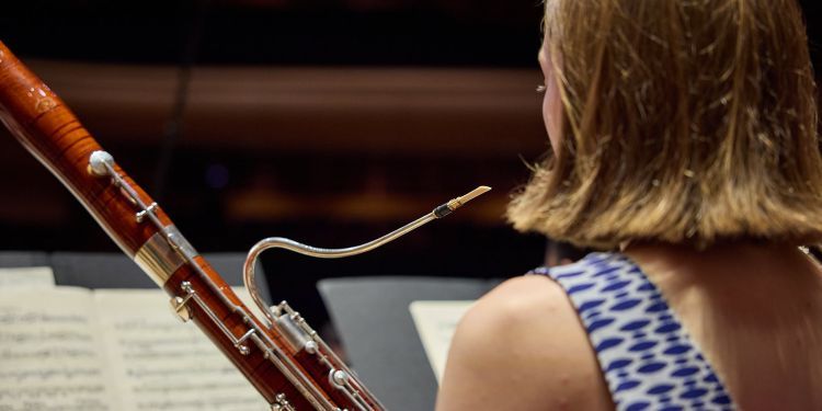 The back of a student playing the bassoon on stage