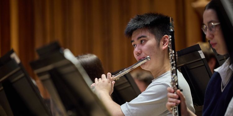 Student playing the flute on stage 