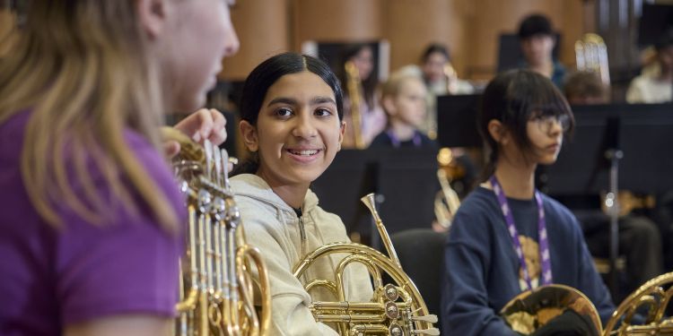 Two brass students smiling at one another