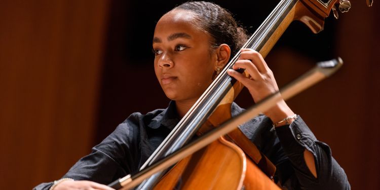 Student playing cello on stage