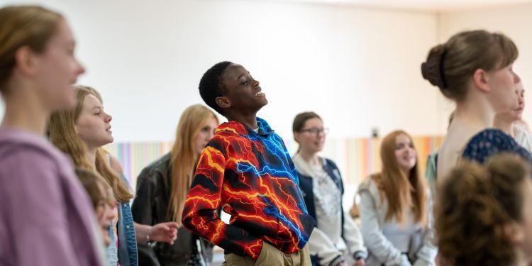 Young boy in red, orange and blue jumper, laughing