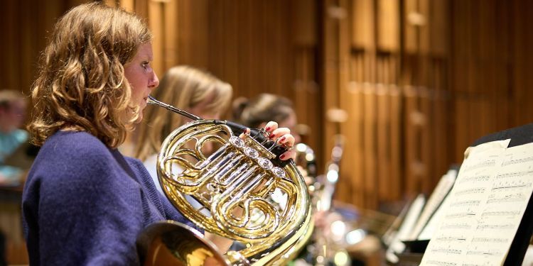 Student on stage playing brass