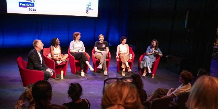 Students and professors on stage sat in chairs during a Making It Work panel discussion