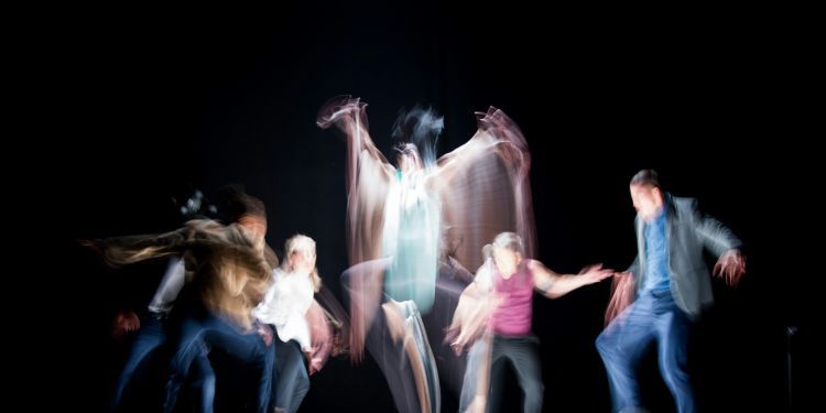 Blurred image of a group of people dancing in a dark room
