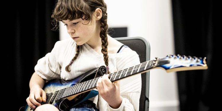 GYA Online student playing a guitar