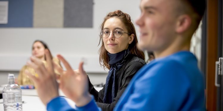 Woman watches a man talk animatedly