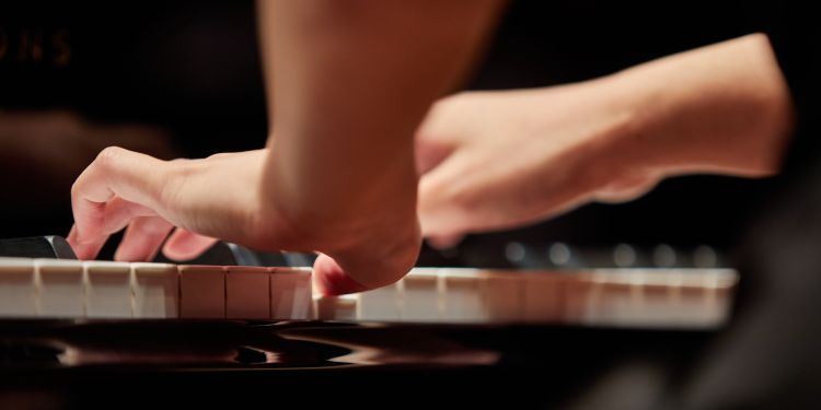 Close up shot of a student playing the piano 