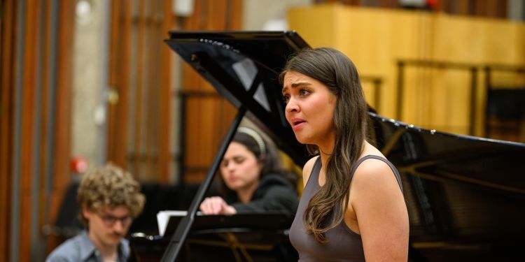Vocal student stood singing in front of a pianist
