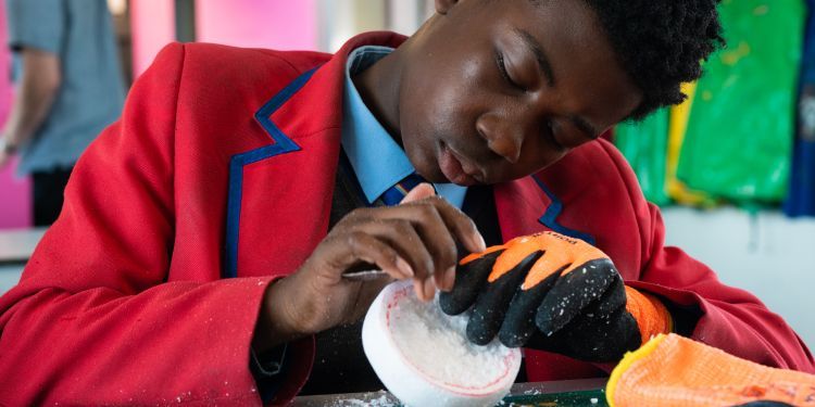 School boy carves his polystyrene tart base