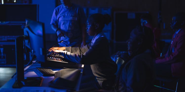 School student works at a lighting desk