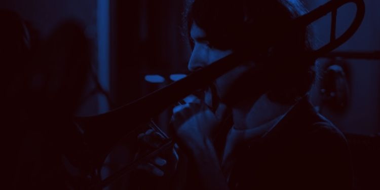 Dark image focusing on a student playing the trumpet 