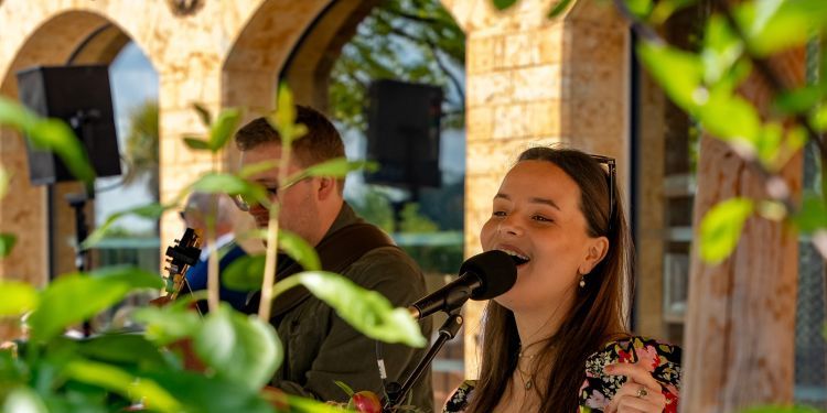 Image of Rosa Witts singing outside in a garden