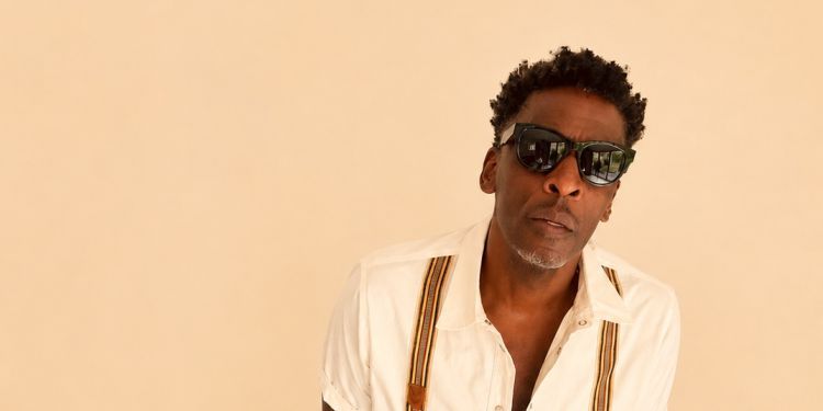 Man posing all dressed in white wearing sunglasses 