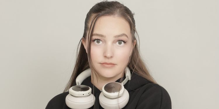 Alberte wearing a black jumper and headphones around her neck
