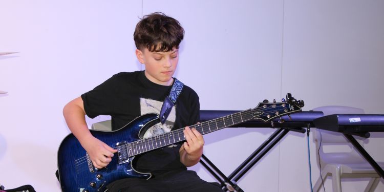 Boy plays a blue electronic guitar