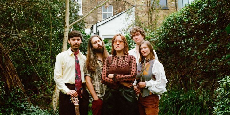 The group  Novos Londrinos standing next to one another in a garden with a building behind them