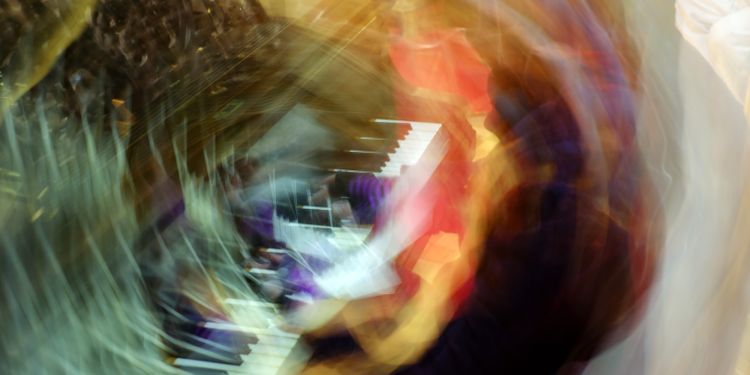 A blurred and distorted image of someone playing a keyboard