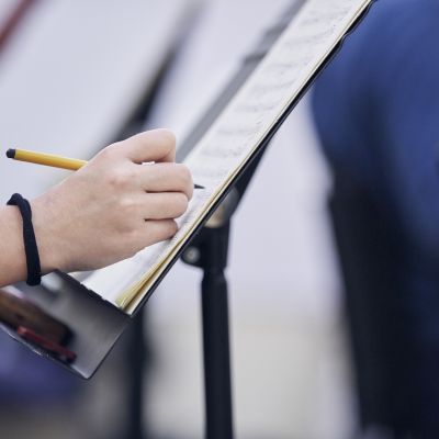 Hand writing notes on sheet music