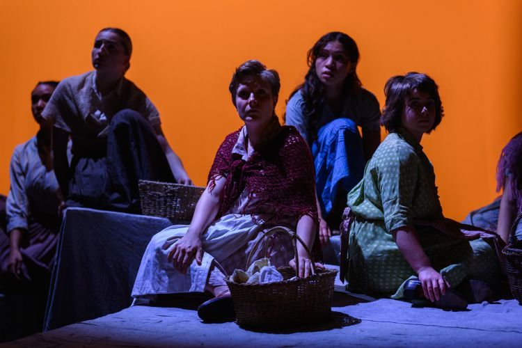 The cast of Yerma sat on the stage looking out to the audience.