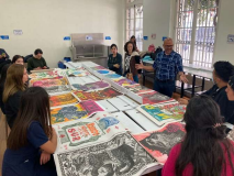 people sitting round a table with large colourful posters on it