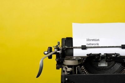 Typewriter against a yellow background, with Librettist Network written on the paper in the typewriter