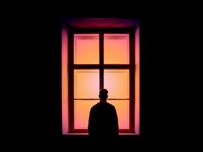 Silhouette of a man standing at a window