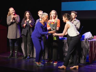 people on stage giving flowers to award winners