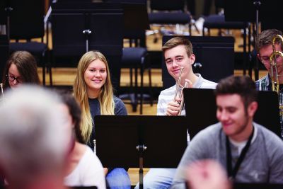 Female and male players in a brass band