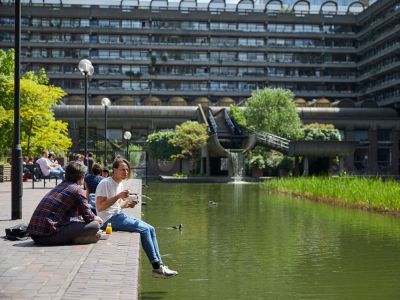 student sat by water next to campus