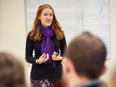 Woman speaking in front of white board