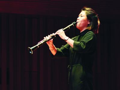 student onstage playing instrument