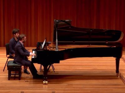 man sat at piano on stage