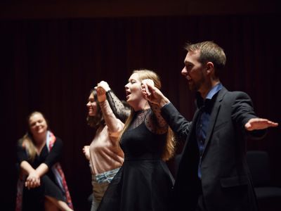 performers holding hands mid-performance on stage