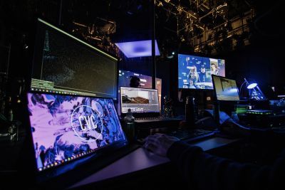 A selection of screens on the lighting desk in a darkened theatre. 