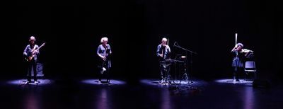 The four members of the Plus Minus Ensemble performing against black background