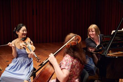 Group of students sat around with instruments and laughing