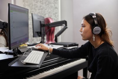 Female participant wears headphones and sits at a computer