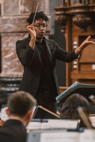 Enyi conducting the LSSO in rehearsals in Belgium