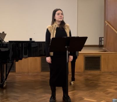 Vocal studies student in front of music stand and piano