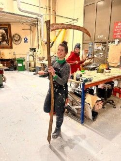 Production Arts student with large piece of wood stage prop